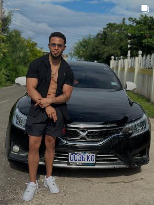 Marcel standing outdoors beside a car.
